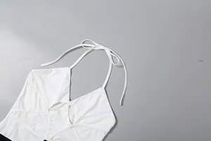 Dettaglio dell'abito bianco con scollo a V all'americana e particolari cut-out