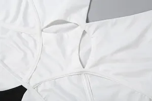 Dettaglio ravvicinato di un abito bodycon bianco e nero con design cut-out e cuciture.