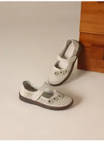 Vista detallada de zapatos de cuero beige con flores y aberturas transpirables.