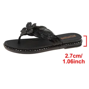 Detailed close-up view showing the 2.7cm heel height of these black floral thong sandals