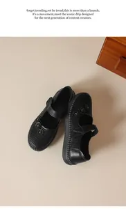 Vista superior de Mary Janes de cuero negro con detalles florales y cierre de velcro