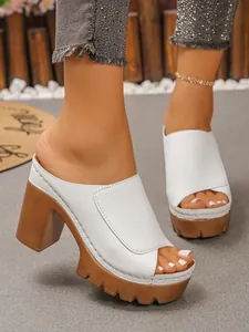 Close-up of elegant white peep-toe platform mules with chunky high heels for summer