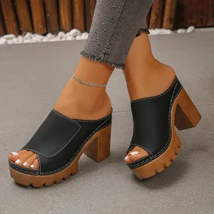 Detailed view of stylish black platform mules featuring chunky heels and white stitching