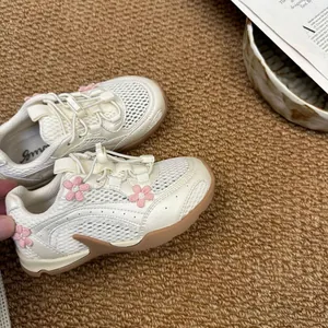 Macro detail of girls breathable mesh sneakers featuring pink 3D flower decorations