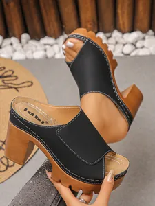 Close-up of black platform chunky heel sandals with peep toe and white stitching