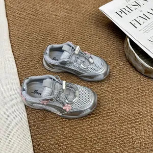 Close-up detail of silver girls' breathable mesh sneakers featuring pink floral accents