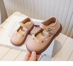 Close-up of pink girls Mary Jane shoes with delicate flower embroidery and soft sole