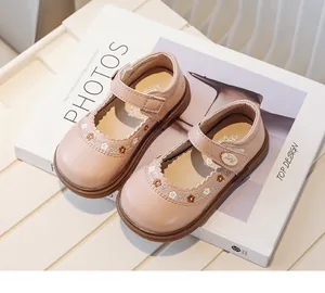 Detailed view of pink embroidered baby girl Mary Jane shoes on a minimalist book prop.