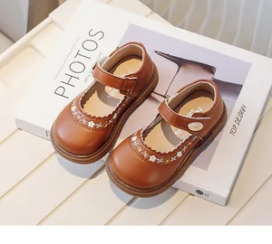 Close-up of brown leather toddler Mary Janes with flower embroidery detail.