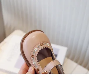 Close-up of pink baby girl Mary Jane shoes with floral embroidery and scalloped edges