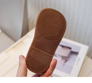 Detailed close-up of brown anti-slip textured rubber sole for toddler girl's shoe size 24