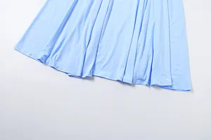 Detailansicht der glatten Stofftextur und des fließenden Saums des hellblauen Kleides