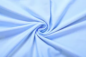 Detaillierte Makroansicht der hellblauen Kleiderstofftextur mit weichen Spiralfalten