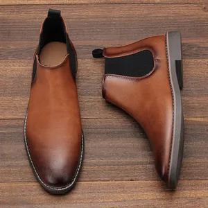 Detailed top-down view of men's stylish brown burnished Chelsea boots on wooden planks