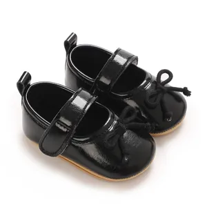 Detailansicht von Baby-Lauflernschuhen aus schwarzem Lackleder mit süßer Schleife