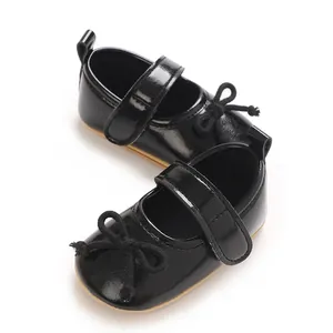 Detailansicht glänzender schwarzer Baby-Lauflernschuhe aus Lackleder mit Schleife