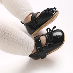 Elegante schwarze Babyschuhe aus Lackleder mit weicher rutschfester Sohle und Schleife.