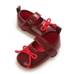 Nahaufnahme von eleganten burgunderroten Baby-Mädchen-Lauflernschuhen mit Schleife