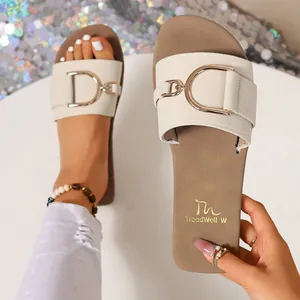 Detailed view of chic beige flat sandal featuring a stylish gold metal D-ring buckle