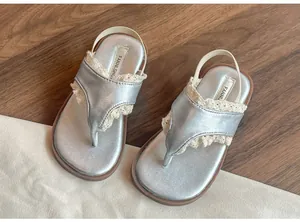 Détail de sandales argentées pour enfants avec dentelle et bride élastique