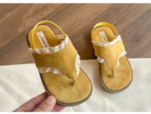 Vue détaillée de tongs jaunes pour enfants avec de la dentelle et une semelle souple