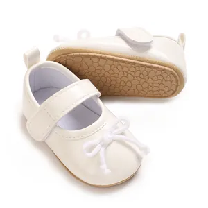 Detailansicht der weißen Baby-Mary-Jane-Schuhe mit rutschfester Gummisohle und Schleifen