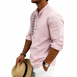 Detail of ethnic embroidery and breathable linen texture on a pink long-sleeved shirt