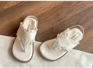 Vue détaillée de sandales enfant crème avec bordure en dentelle et semelle souple