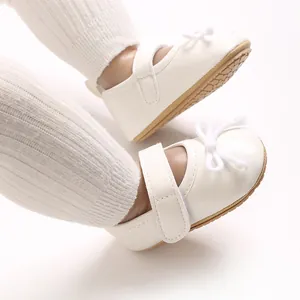 Nahaufnahme von weißen Lauflernschuhen für Mädchen mit Schleife und weicher Anti-Rutsch-Sohle