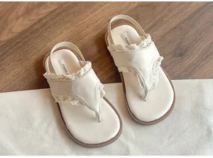 Détail de sandales entredoigts pour filles, blanc crème avec dentelle et semelle souple