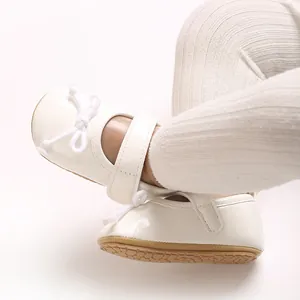 Detailaufnahme von cremefarbenen Prinzessinnen-Lauflernschuhen für Babys mit Schleife und Gummisohle