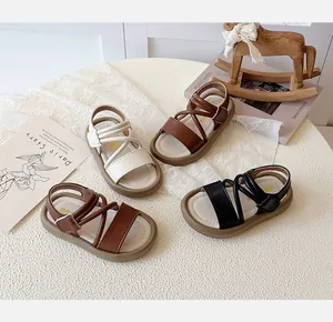 Detailed group shot of girls' Roman sandals in brown, cream, and black leather styles.