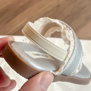 Sandale argentée pour bébé avec brides en dentelle blanche et bande élastique