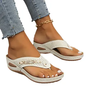 Chanclas blancas de cuña con hebilla metálica decorativa y tiras perforadas