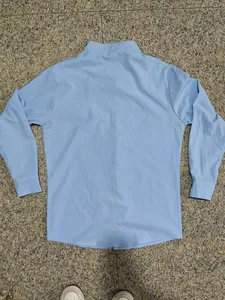 Vista posteriore dettagliata di una camicia in lino azzurro a maniche lunghe con collo alla coreana