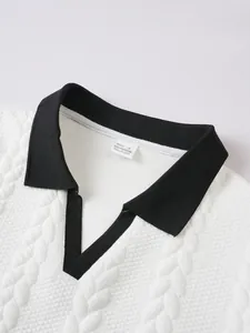 Detailed view of men's white jacquard polo shirt with contrast black collar design.