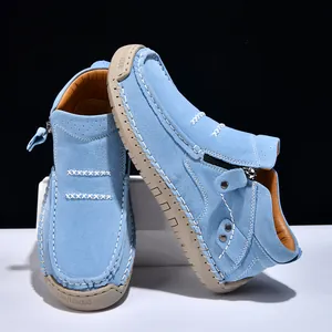 Detail view of light blue suede high-top loafers with white stitching and side zipper
