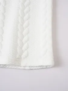 Close-up of white cable knit and honeycomb texture on a men's polo shirt