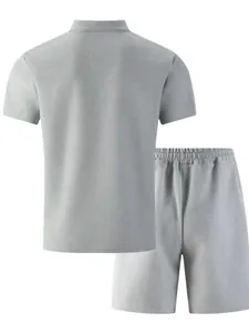 Rückansicht eines grauen Waffelstrick-Sets für Herren mit Polo-Shirt und Shorts.