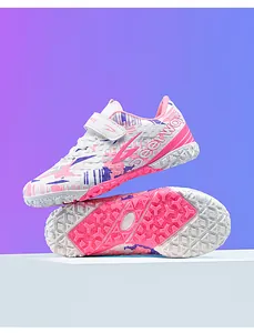 Detailed view of TF turf soccer shoes showing pink camouflage and anti-slip sole