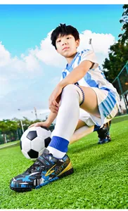Young boy wearing blue and black TF soccer cleats with Beerway logo on grass field