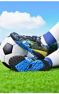 Close-up detail of TF turf soccer shoe sole with DEERWAY branding and blue camouflage
