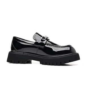 Side view of black patent leather men's loafers featuring thick lug soles and a metal buckle.