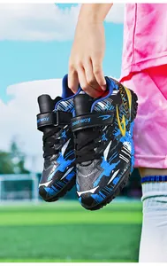 Close-up of kids turf soccer shoes with blue and black pattern and velcro straps