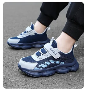 Detailansicht von blau-weißen Kinder-Sportschuhen aus Mesh auf strukturiertem Boden