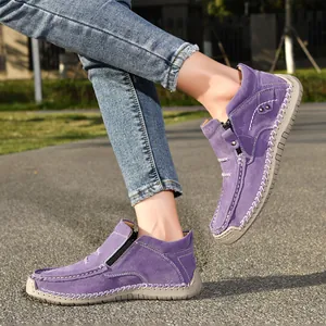 Detail of purple suede high-top loafers with contrast stitching in outdoor setting