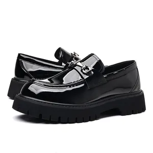 Detail of men's black patent leather loafers with thick platform soles and silver metal bit.