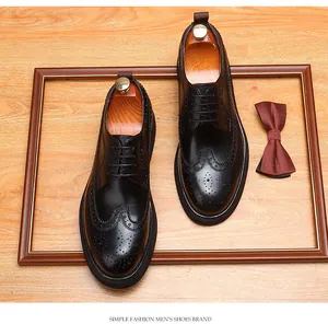 Klassieke zwarte heren brogue leren schoenen in een lijst met een vlinderdas