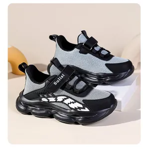 Nahaufnahme grauer und schwarzer Kinder-Mesh-Sneaker mit dicker Sohle und Klettverschluss.