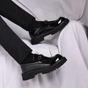 Close-up of men's black patent leather loafers with thick soles and metal buckle detail